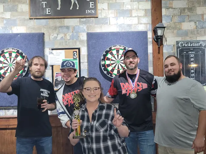 Group of darts players posing together inside a Houston bar